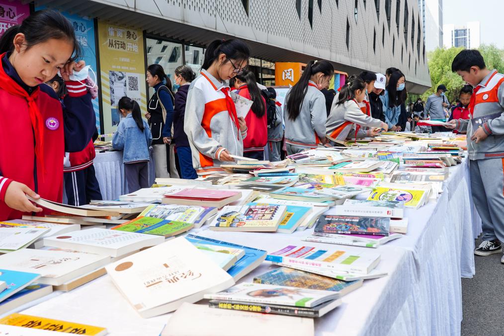 4月20日,山东省济南市第十四届“书香泉城”全民阅读节在济南市图书馆启动,小员工在阅读节上参与换书活动。新华社记者 朱峥 摄